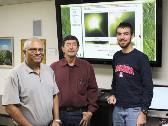 N.H. Samarasinha, S.M. Larson, and M.P. Martin (left to right) in front of a display showing the results from the web facility.