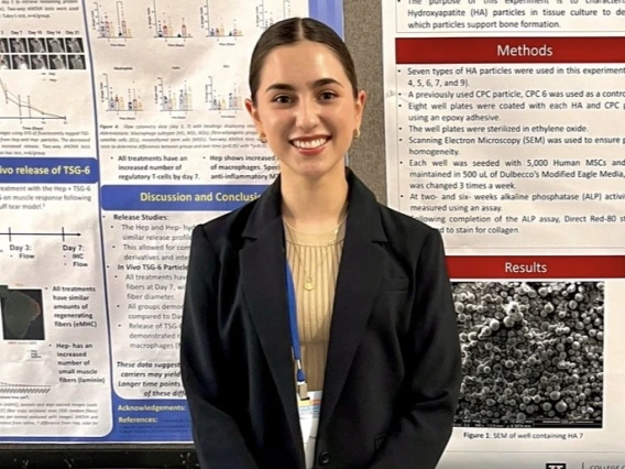 Stephany Maldonado standing next to poster.