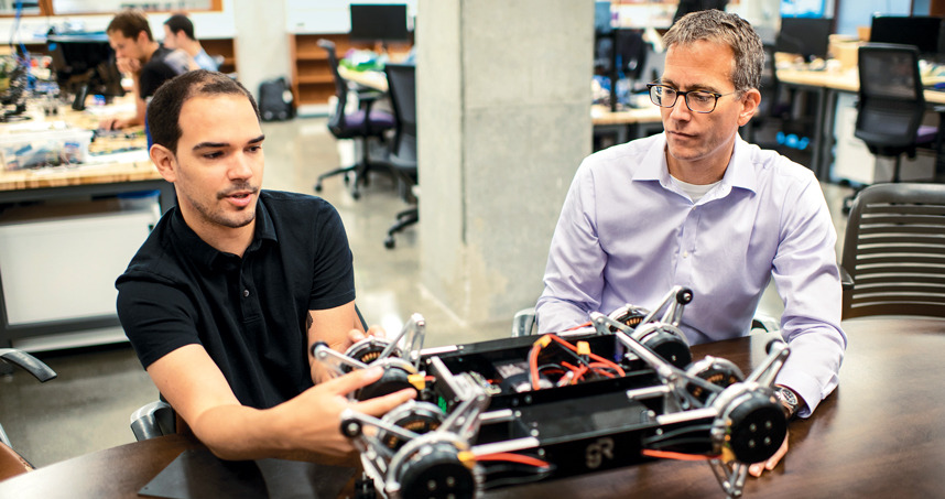 Todd Murphey working on robotics with student.