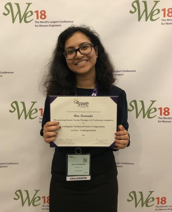 Ava Karanjia poses with her first-place award for the undergraduate collegiate technical poster competition at the Society of Women Engineers Conference.